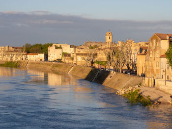 River amidst buildings in city against sky