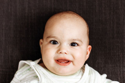 Portrait of cute baby boy lying down on bed