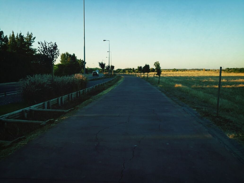 the way forward, clear sky, diminishing perspective, vanishing point, road, copy space, sky, grass, tree, tranquility, field, transportation, landscape, footpath, tranquil scene, railing, empty, shadow, nature, long