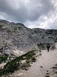 Rear view of a men walking on mountain against sky