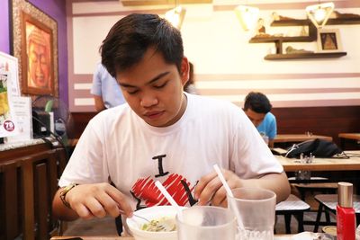 Man looking away while sitting at restaurant