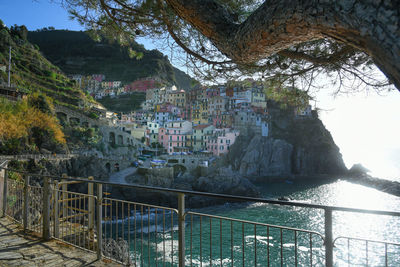 Buildings by sea against sky