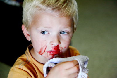 Close-up of sad boy with blood on nose