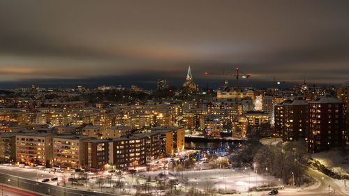 Illuminated cityscape against sky at night