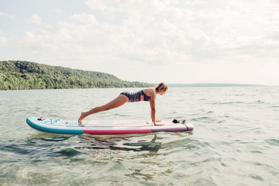 Side view of senior woman in sea against sky