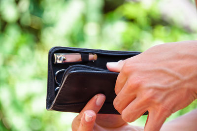 Close-up of cropped hand holding purse