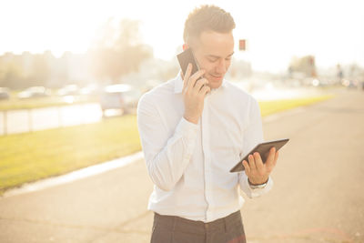 Midsection of man using mobile phone