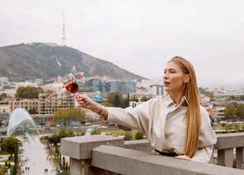 Young woman splashing red wine