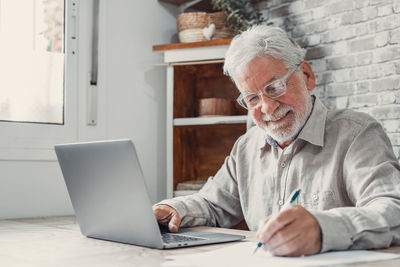 Senior man using laptop at office