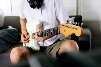 Midsection of man playing guitar