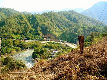 Scenic view of river by mountains against sky