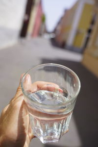 Close-up of hand holding glass of water