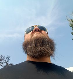Rear view of man wearing sunglasses against sky