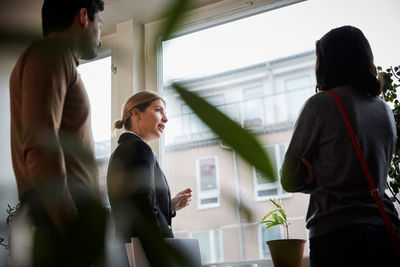 Low angle view of real estate agent talking to couple at new home