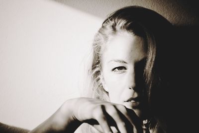 Close-up portrait of beautiful woman against wall