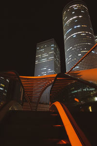 Low angle view of illuminated buildings against clear sky at night