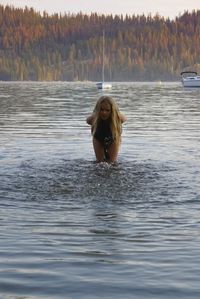 Girl playing in lake during autumn