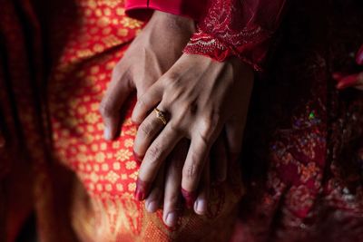 Midsection of bride and groom holding hands