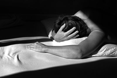 Midsection of woman relaxing on bed at home