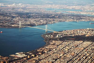 Aerial view of cityscape by sea against sky