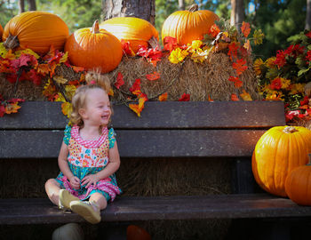 Smiling girl sitting on bench during halloween