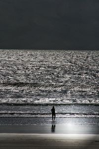 Rear view of woman walking at beach