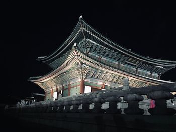 Low angle view of illuminated building against sky at night