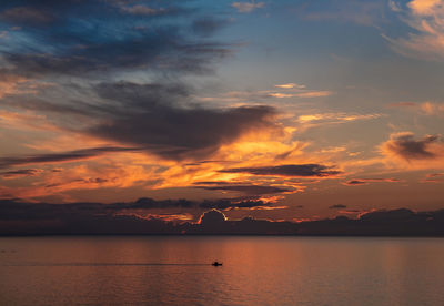 Scenic view of sea against dramatic sky during sunset