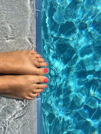 Low section of woman by swimming pool