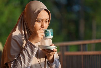 Muslim woman sitting enjoying tea in the sun