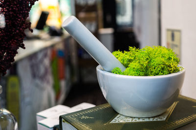 Close-up of salad in mortar and pestle on book