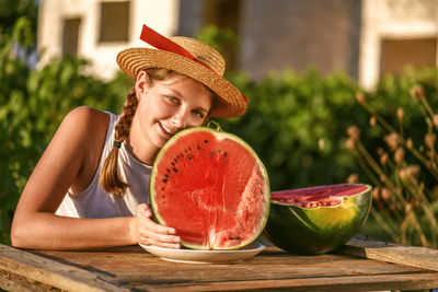 Happy smiling girl with half red fresh watermelon enjoying summer life outdoors. summer lifestyle