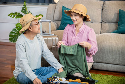 Friends sitting on sofa at home