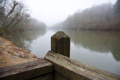 Close-up of wooden structure in lake against sky