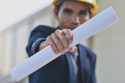 Portrait of man holding umbrella standing on paper