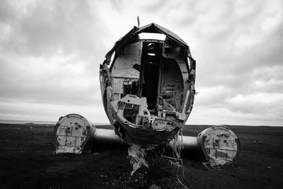 Abandoned airplane on land against sky