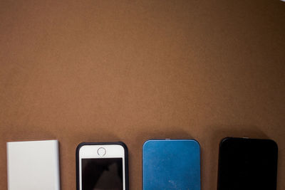 Close-up of mobile phones arranged on brown table