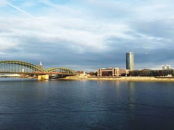 Bridge over river against cloudy sky