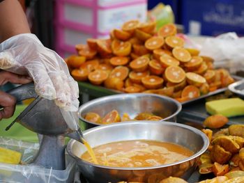 Midsection of person preparing food at market stall
