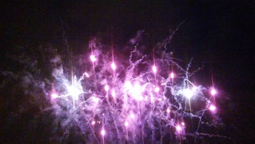 Low angle view of firework display at night