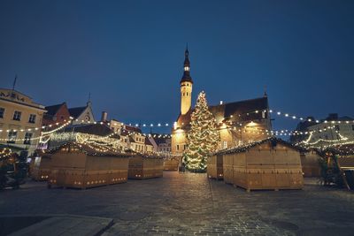 Illuminated buildings against sky at night