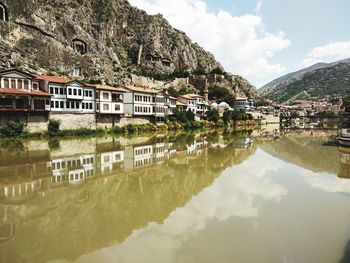 Reflection of buildings on river against sky