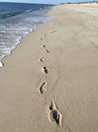 High angle view of footprints on sand at beach