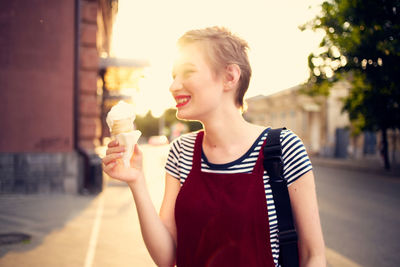Girl holding ice cream in city