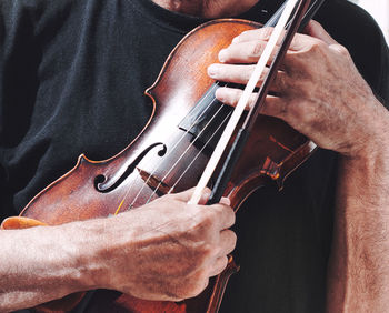 An old violin and a bow in the hands of a gipsy violinist.