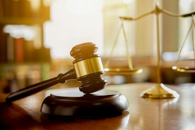 Close-up of gavel and weight scale on table