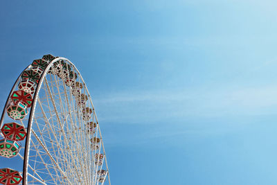 Low angle view of ferris wheel against blue sky