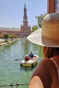 Rear view of people on boat in canal