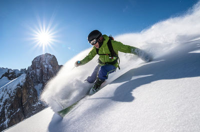 Adult man powder skiing in the backcountry of the italian dolomites.