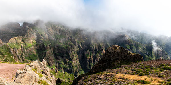 Panoramic view of land and mountains against sky